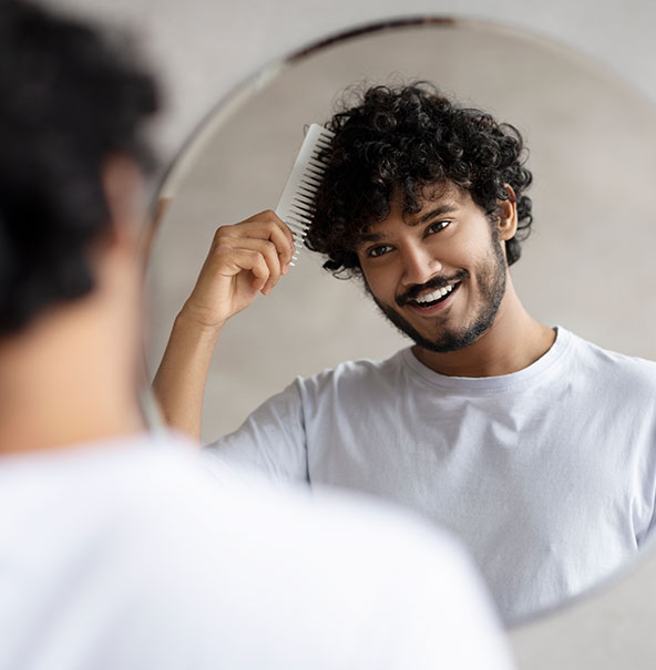 Man in mirror brushing hair